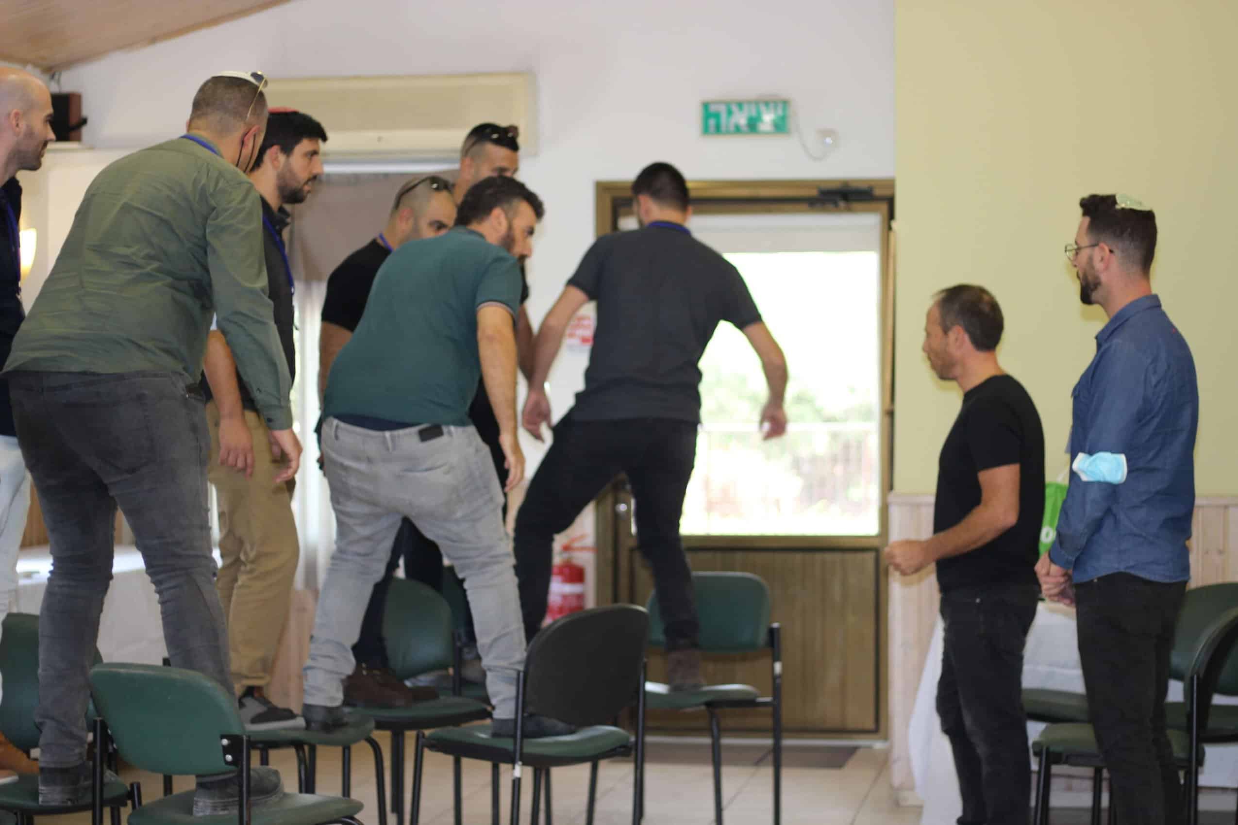 משתתפים צוחקים בפעילות אלתור לצוותים